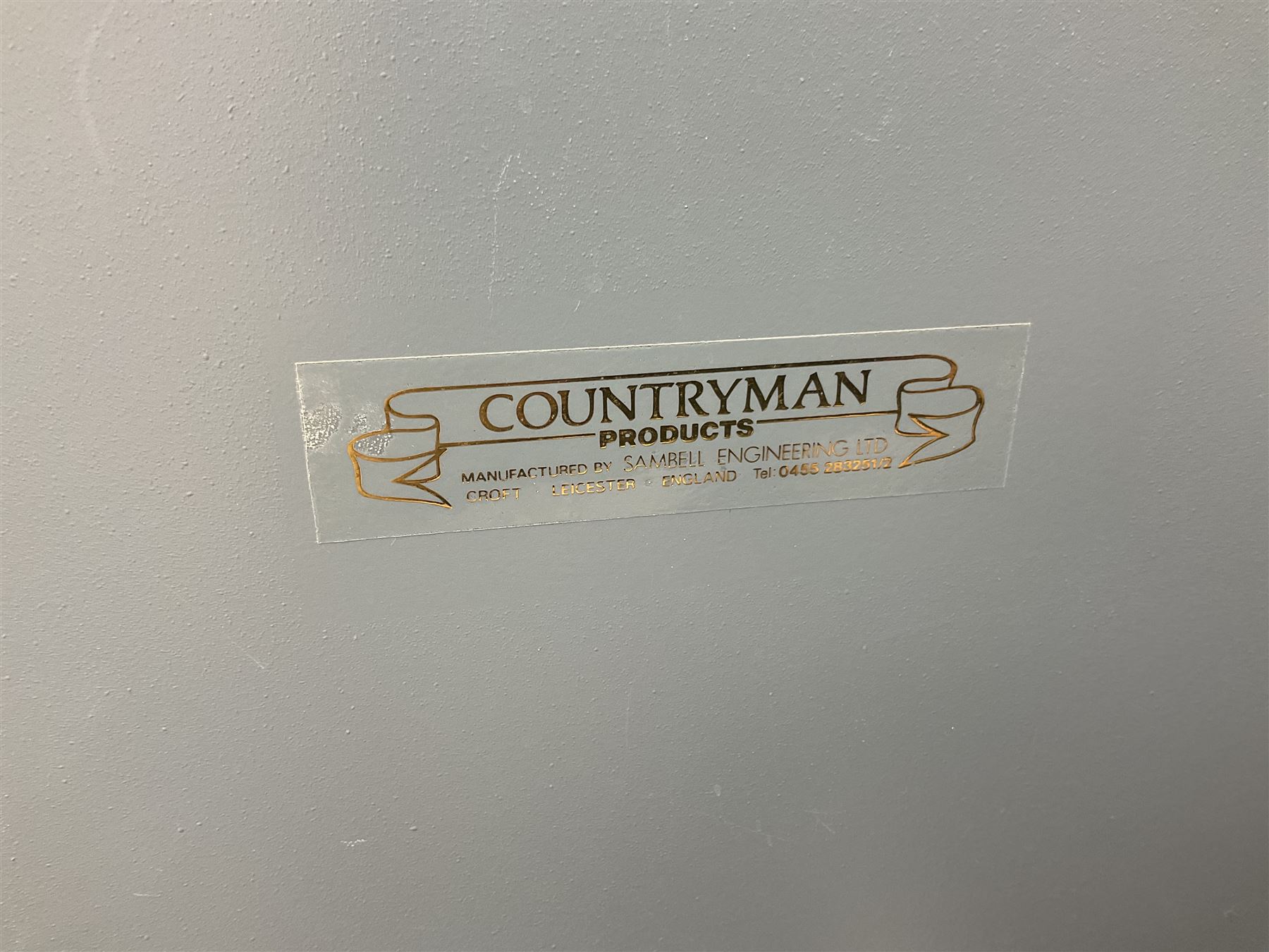 Two-tone grey steel wall-mounting gun cabinet by Sambell Engineering to accommodate six guns with fixed shelf over, gun space int. H132cm W36.5cm D23.5cm, the single double-locking door with two sets of keys, ext. H154cm W37cm D27cm