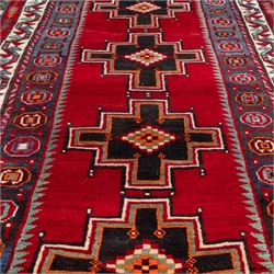 South-west Persian Lori rug, the red field centred by four linked stepped cruciform medallions with polychrome diamond centres, enclosed by a blue ground octagonal motif border, ivory angular meander band and red geometric outer border