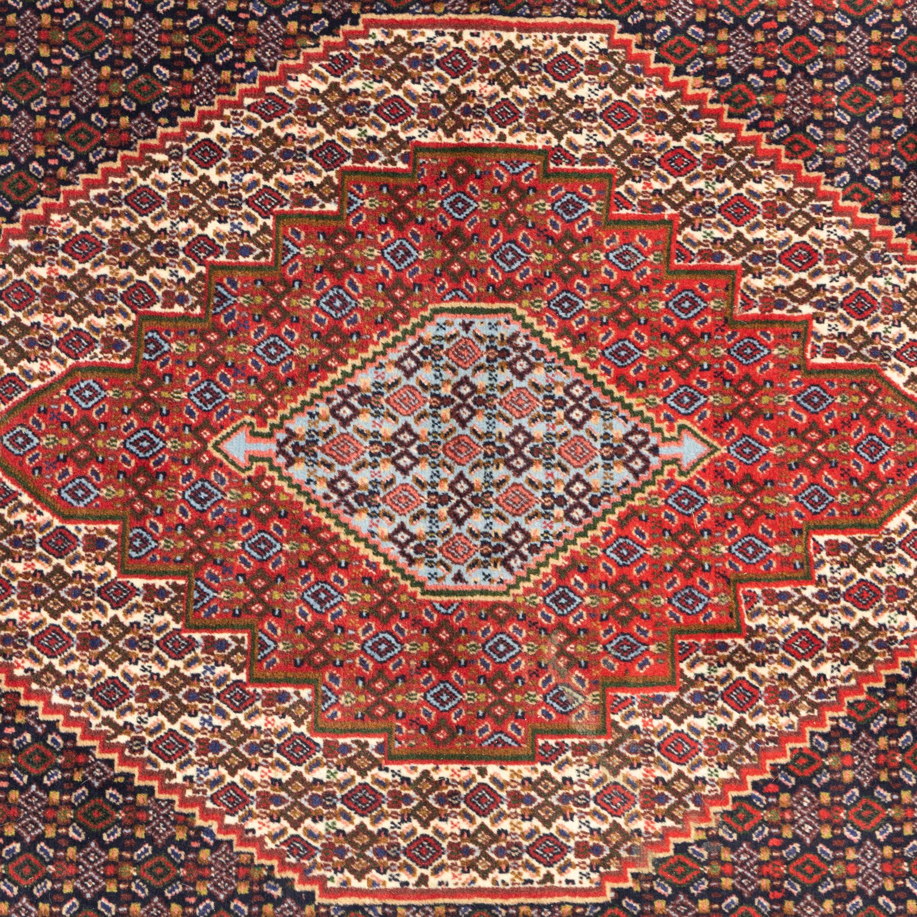 Persian Ardakan rug, featuring central elongated diamond medallion with serrated edges on a repeat boteh field, framed by triple guard borders with red floral scroll design