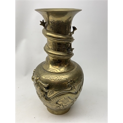 A large Chinese brass vase, of ovoid form with tall neck and flared rim, decorated in relief with dragons chasing a flaming pearl, and further incised with clouds and other detail, the base with relief dragon detail and character mark, H41