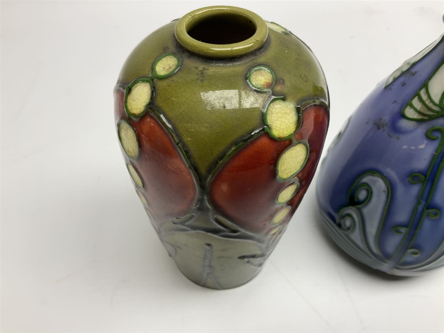 Minton Secessionist vase, with tube-lined stylised flower head decoration on a blue ground, printed mark to base 'Minton Ltd, No. 30', together with another Minton Secessionist tubelined vase,  printed mark to base 'Minton Ltd, No. 16', tallest example H13.5cm