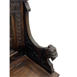 19th century heavily carved oak settle, the moulded upper rail over triangular foliage carved frieze, three Flemish style carved panels depicting tavern scenes, acanthus carved uprights terminating to lion carved arms, hinged box seat, the panelled front carved with lion masks and extending scrolled acanthus leaves, on moulded skirt base