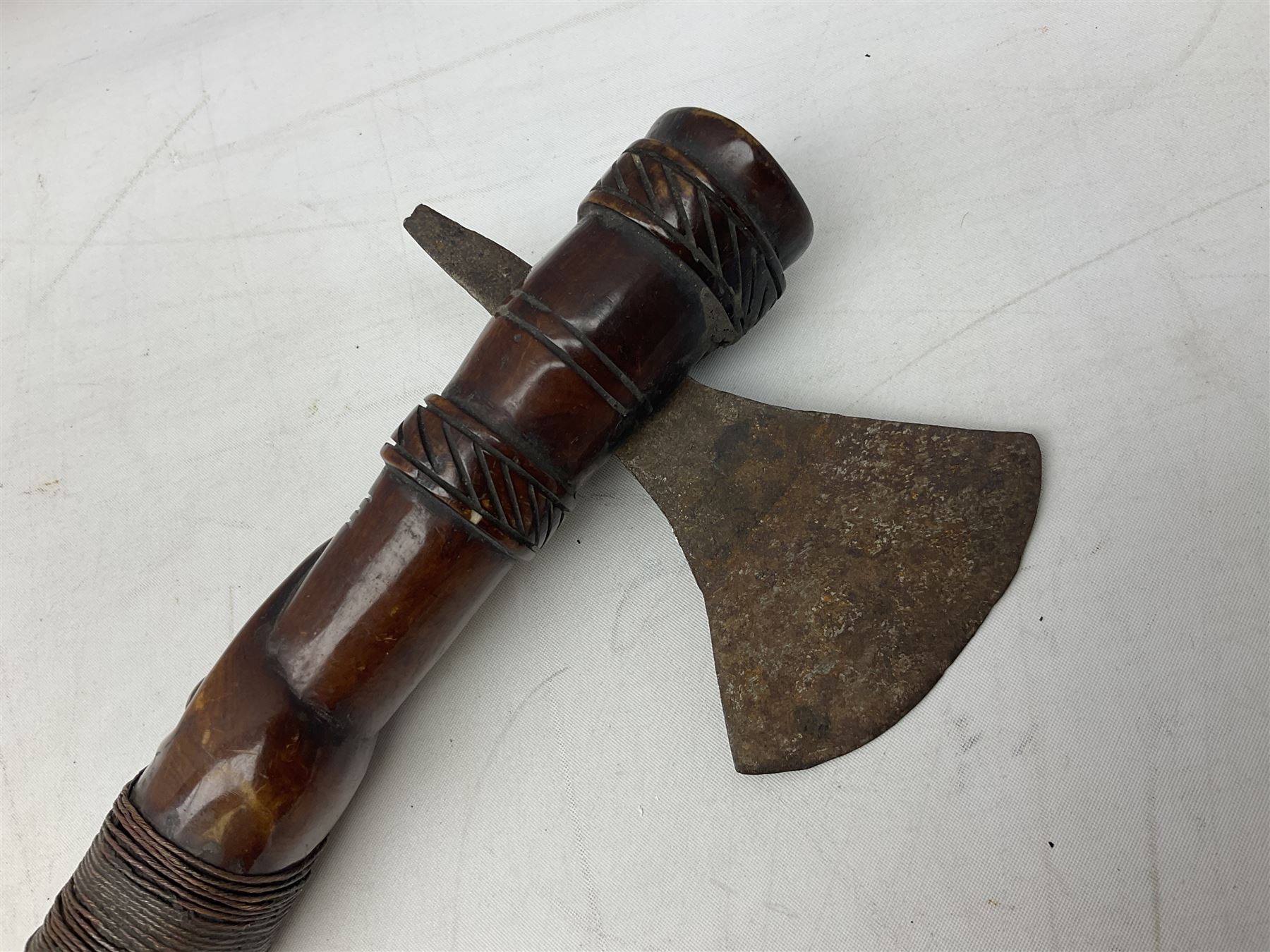 Tribal Art - an African axe, possibly Yoruba, the bone shaft carved as two cord bound stylised figures with iron fan-shaped blade, L35cm overall; and 19th century harpoon or spear head of square section with two long fixing arms on cut-down ash shaft L57cm (2)