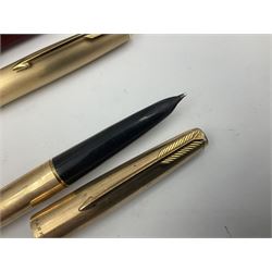 Three rolled gold Parker fountain pens, comprising an example with a gold nib marked 14K 585 and barrel with a shell stamp, a Parker 61 fountain pen with inset gold arrow to the nib, and another similar, all with striated decoration and arrow clips to the caps, L13cm, one with box