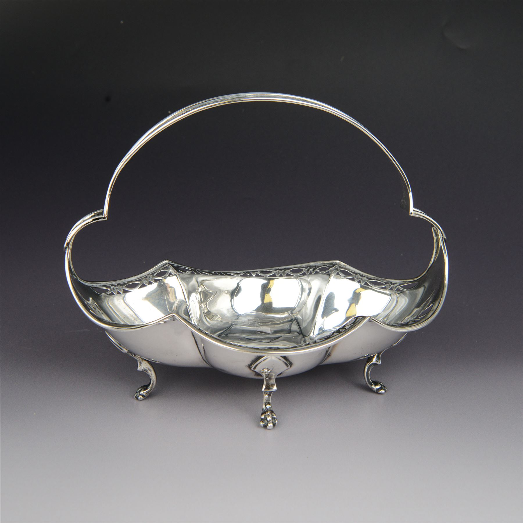 1920s silver basket, of navette form with pierced rim and lobed bowl, with fined pierced handle and upon four paw feet, hallmarked Sibray, Hall & Co Ltd, Sheffield 1923, including handle H18.5cm
