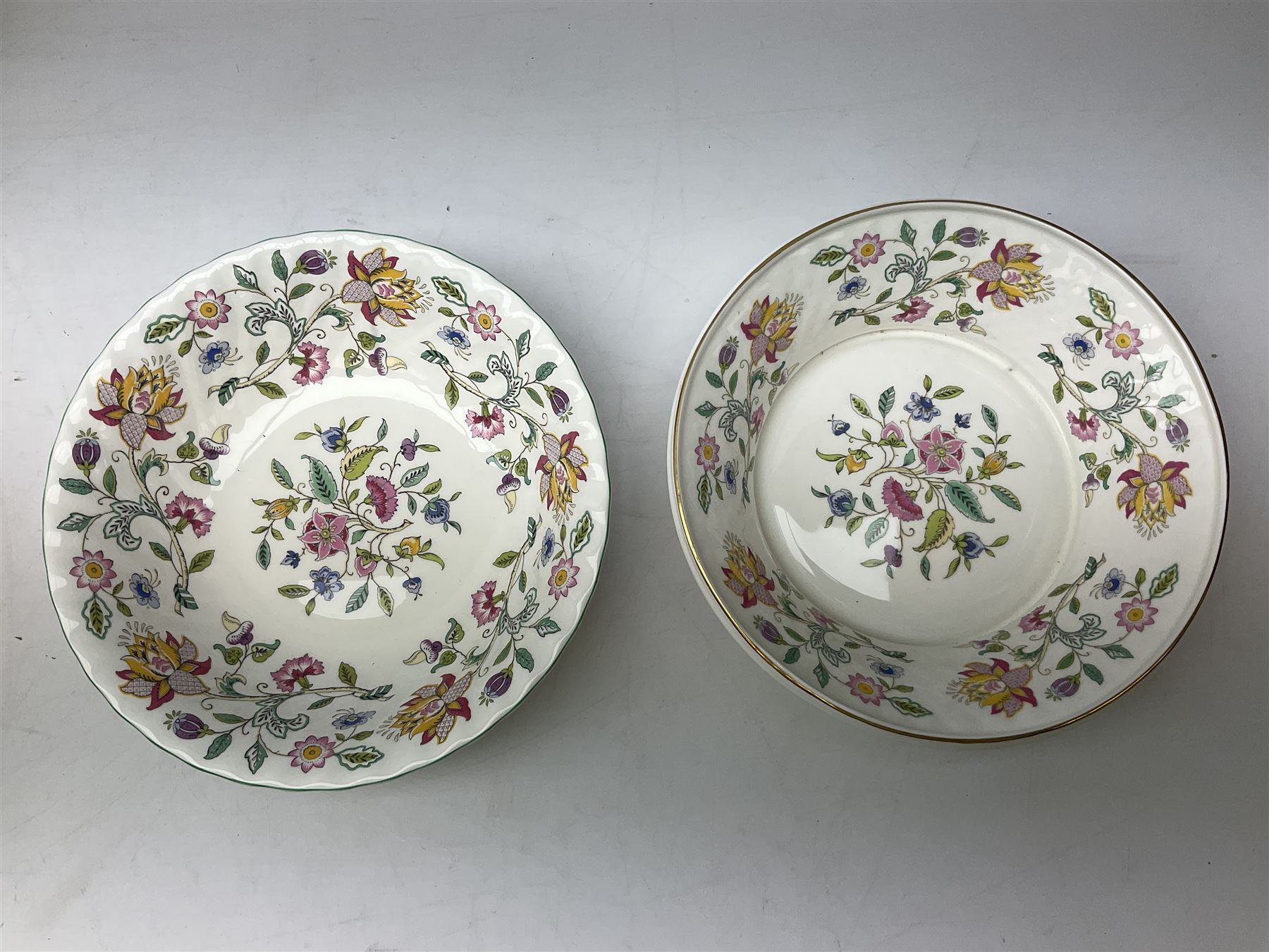 Minton Haddon Hall pattern tea and dinner wares, including basket dish, two covered tureens, six dinner plates, eight dessert plates, twelve tea plates, six soup bowls, six cereal bowls, teapot, coffee pot, milk jug, covered sucrier twelve tea cups and saucers, six mugs, footed bon bon dish, pair of candlestick holders, cake knife and slice etc (81)