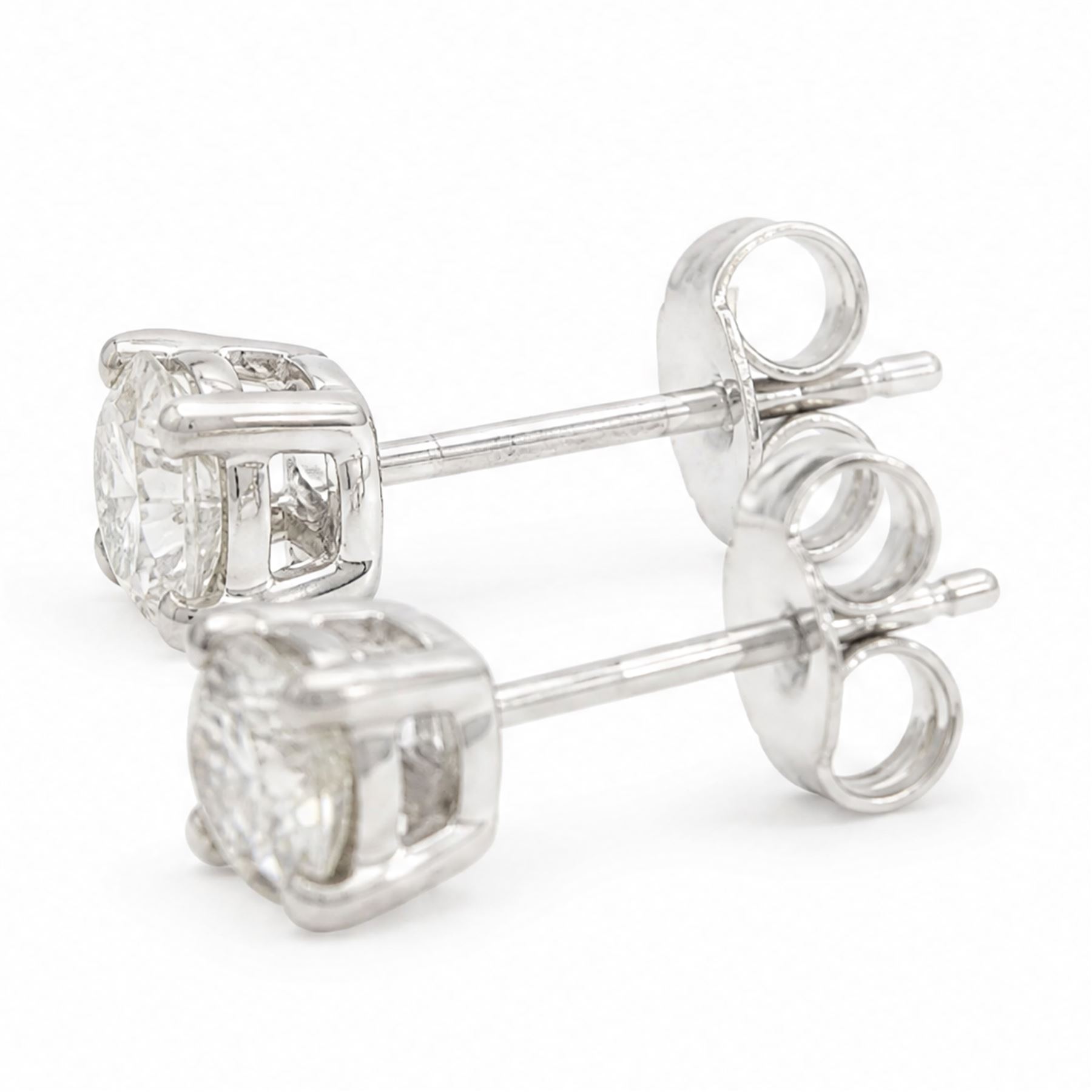 Pair of platinum diamond earrings, each stud four claw set with a single round brilliant cut diamond, stamped Pt 950, total diamond weight approx 0.85 carat