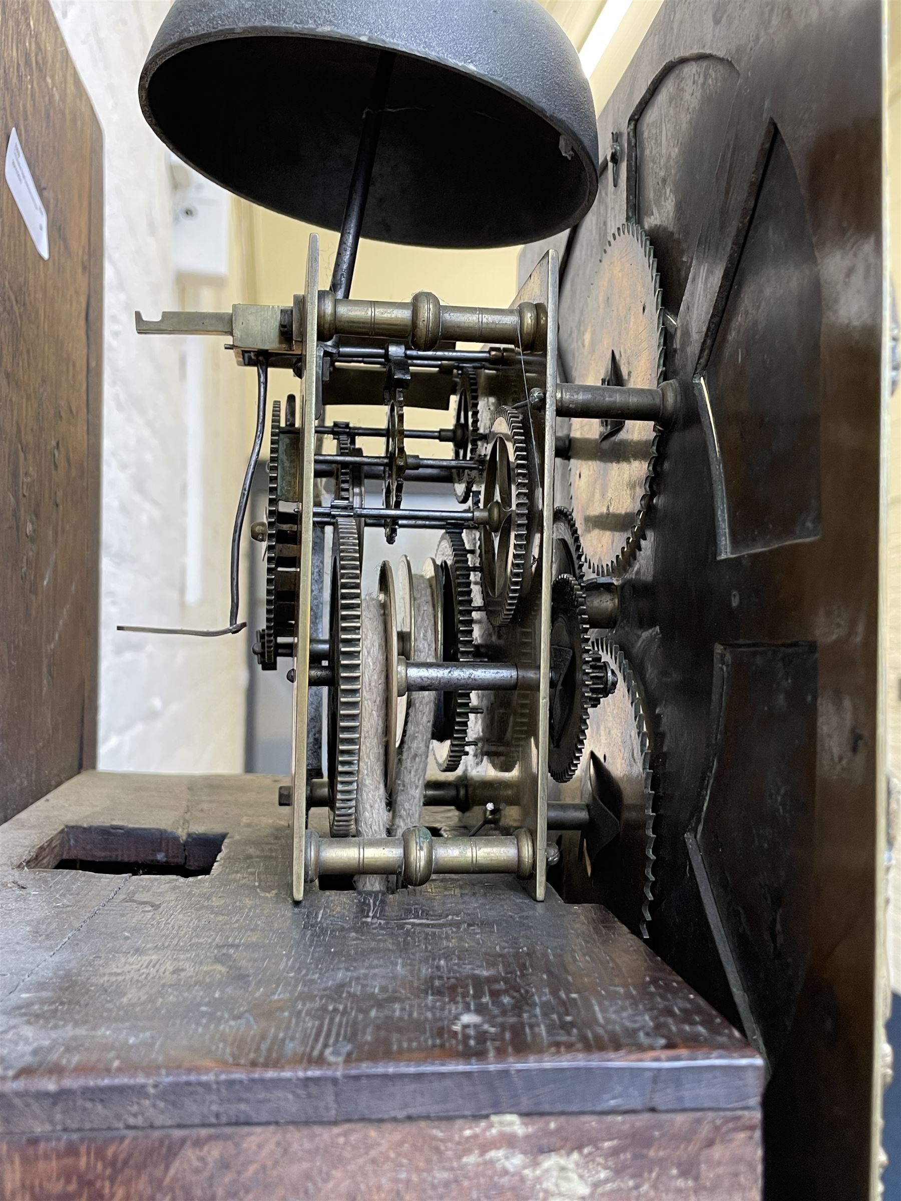 18th century c1760 oak cased George III longcase clock by William Eastwood of Burnley, with a stepped caddy top on a projecting cornice and blind frieze, square glazed door flanked by two turned pillars with gesso capitals, trunk with conforming recessed pillars and a full length wavy topped door, on a square plinth with a raised panel and shaped skirting, 12” square brass dial, 11” chapter ring with Roman numerals and five-minute Arabic's,  