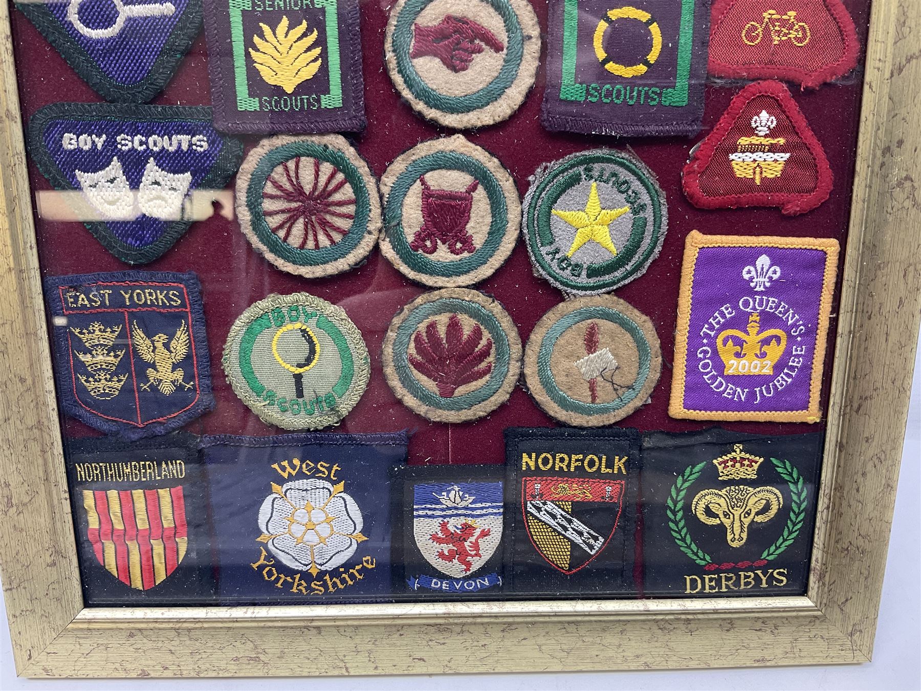 Boy Scout Interest; framed collection of Boy Scouts cloth insignias, to include badges from East Yorkshire, Northumberland, West Yorkshire, Devon, Norfolk and Derby, thirty four badges in total  