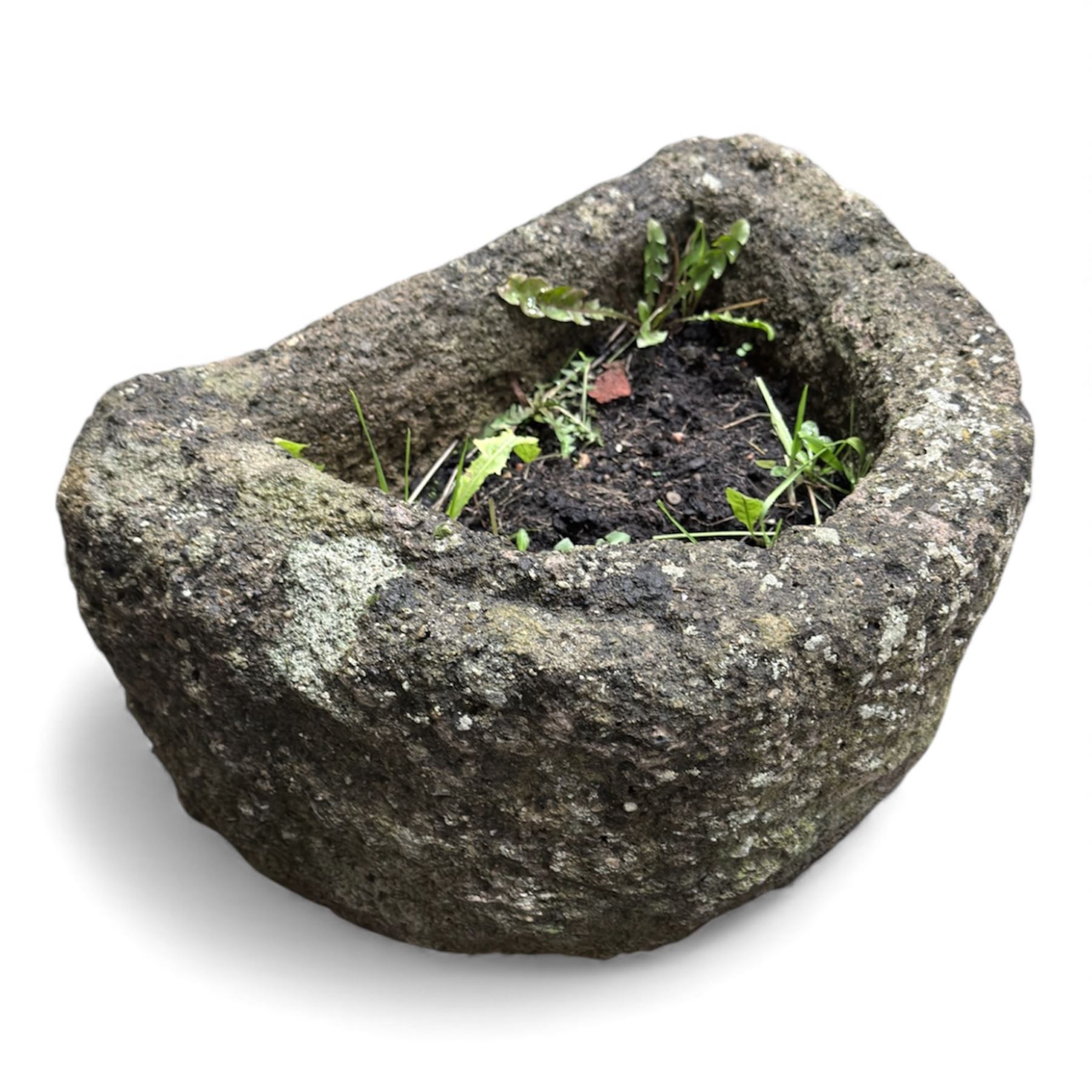 Collection of cast stone garden objects including mill stone, trough, planter, and faces