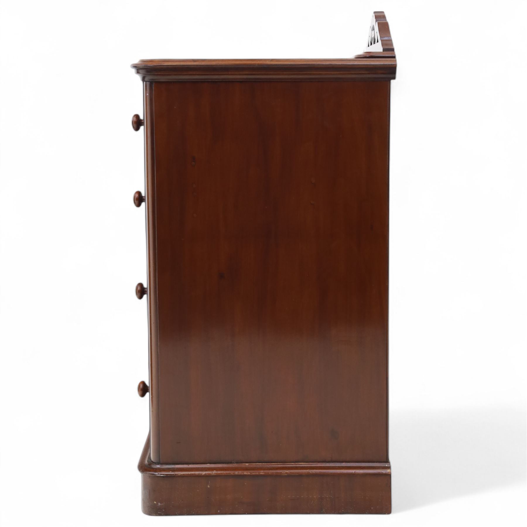 Pair of tall Victorian mahogany bedside chests, of narrow upright form, rectangular top with moulded edge, the back with raised pierced fretwork gallery, above four graduated drawers with knob handles, raised on a plinth base 