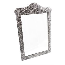 Early 20th century continental silver mounted dressing table top mirror, of rectangular form, the frame embossed with vacant reserve, lattice work, flower heads and C scrolls, with easel style support verso, unmarked but tests as silver, overall H49.5cm W31.5cm