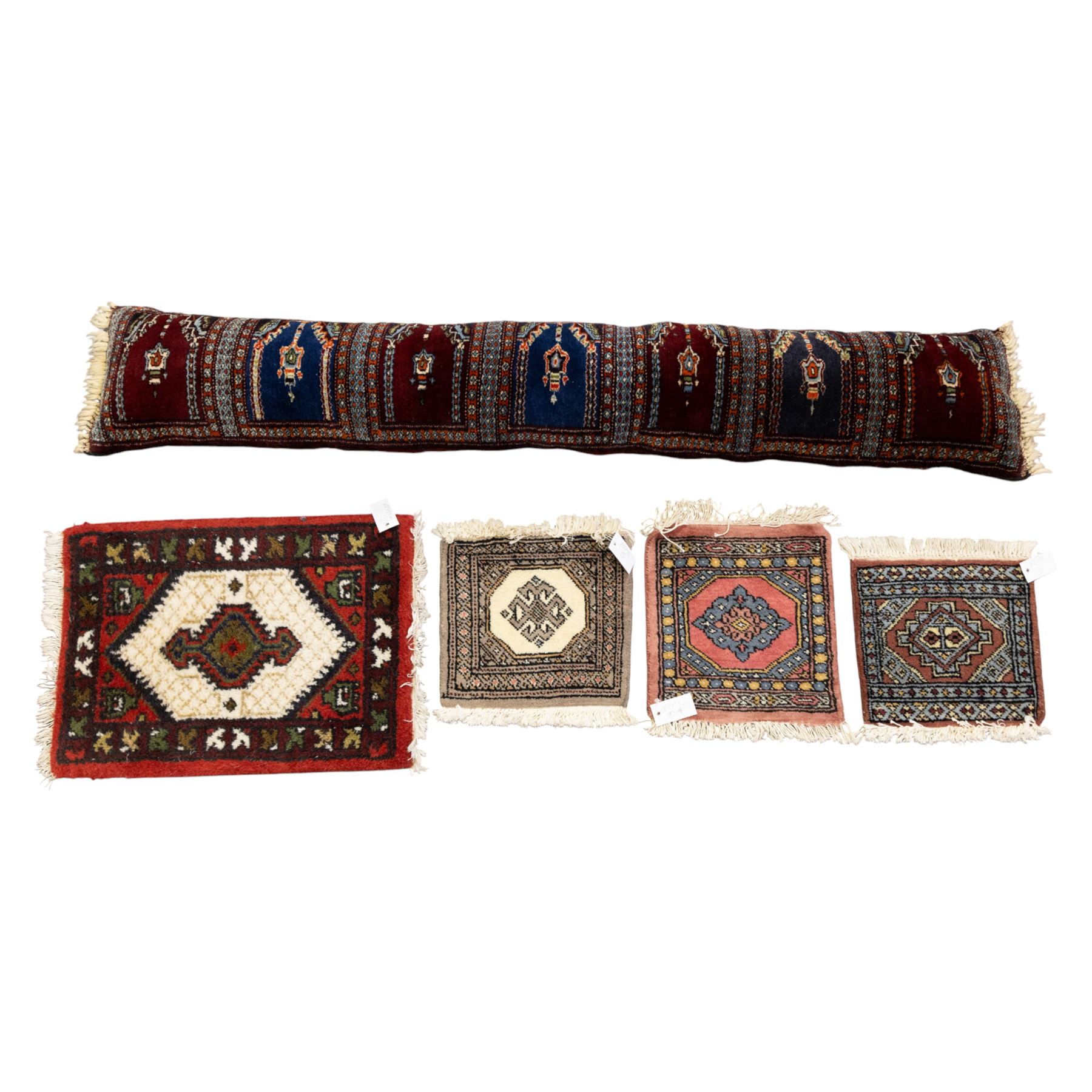 Long flatweave Kilim textile cushion, in crimson and decorated with geometric motifs and cotton fringe ends, 151cm, together with four modern hand-knotted rug mats with geometric designs, the largest 65x43cm, (5)