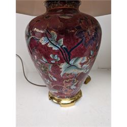 Ceramic table lamp of baluster form decorated with flowers on a burgundy ground, together with a glass lamp 