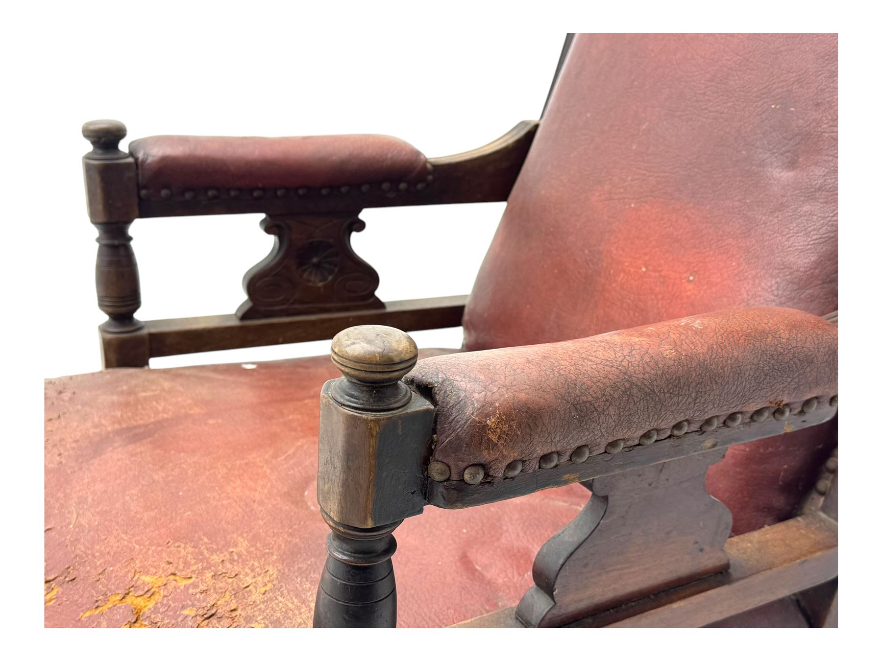 Victorian walnut framed armchair, shaped pediment carved with scrolling foliage, upholstered in leather, on ring turned front feet