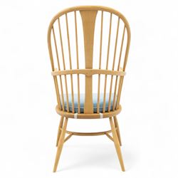 Ercol - ‘Chairmakers’ armchair, of traditional Windsor form in light ash, featuring a hoop back with four spindles and central splat, curved arms and turned supports, dished seat with upholstered blue cushion
