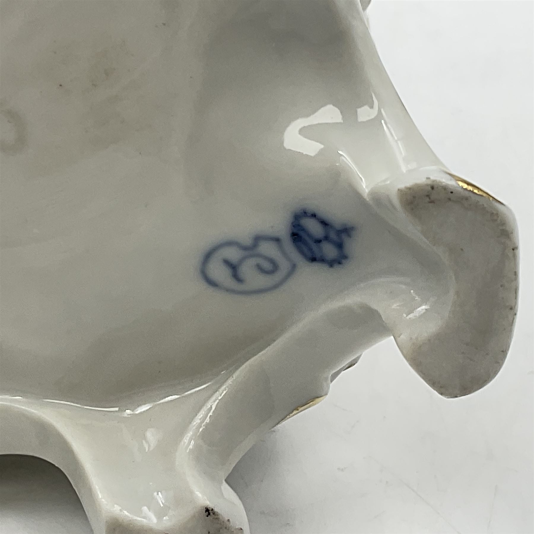 Figure group, probably Volkstedt, modelled as a courting couple seated before a table, the ornate bench and table conforming with and leading from the gilt heightened scrolling base, with blue painted mark beneath, H14.5cm
