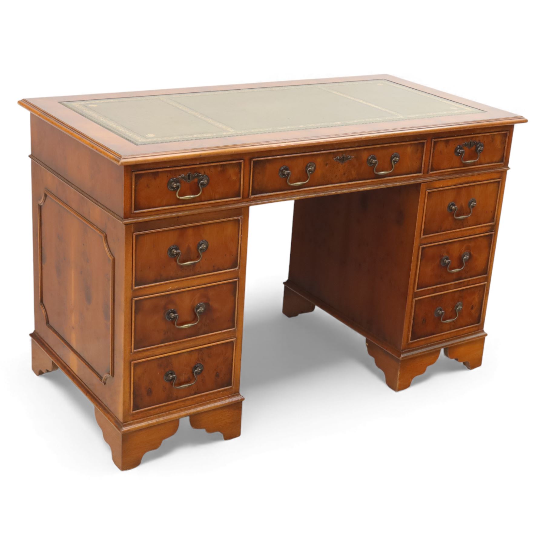 Late 20th century yew wood nine drawer writing desk, rectangular top inset with gilt-tooled green leather, above an arrangement of nine drawers with brass swan-neck handles, raised on bracket feet