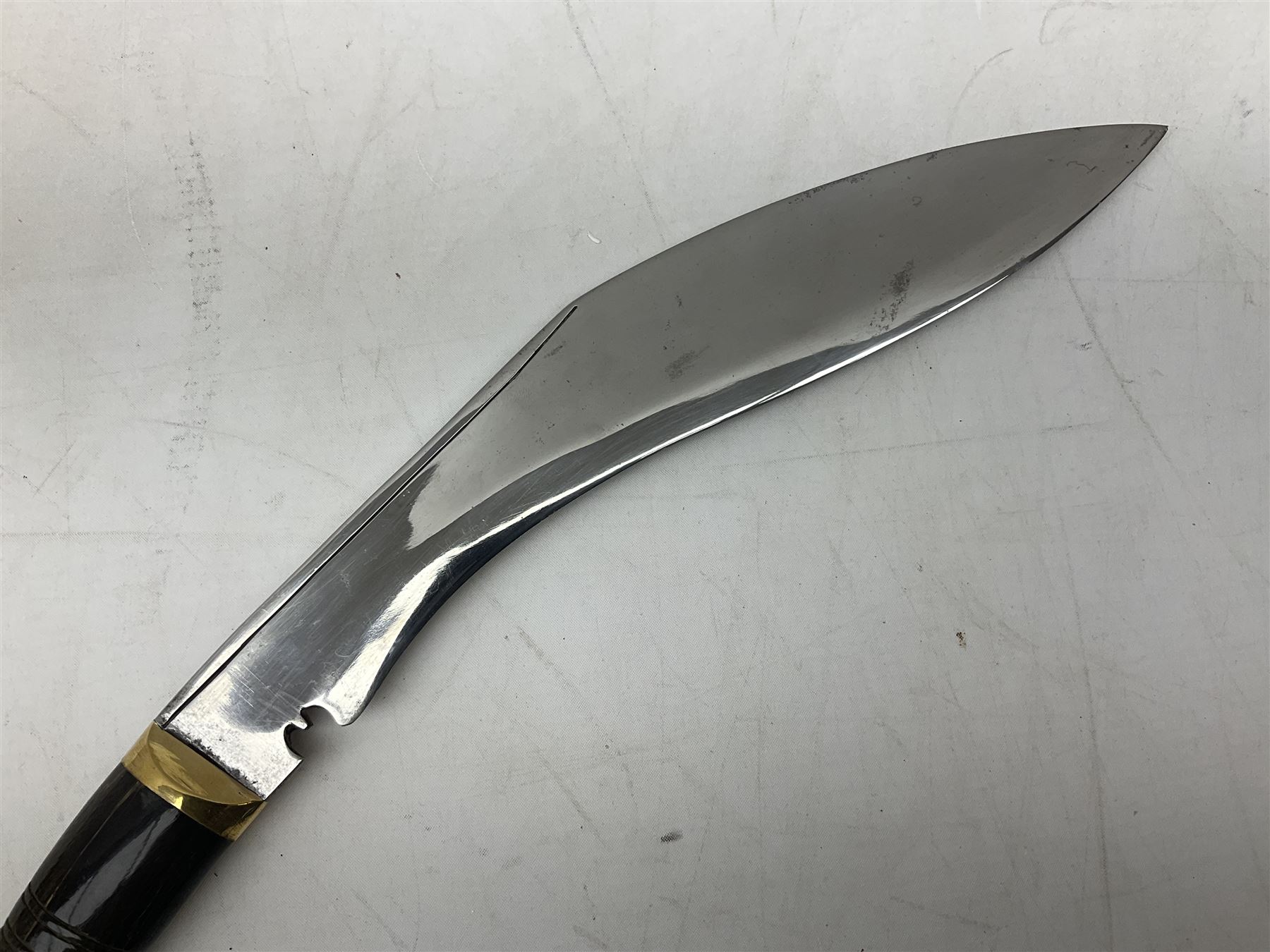 Ceremonial kukri, the 28.5cm curving blade inscribed 'O RDEP NEPAL 9/81' with brass mounted horn grip; in gloss black scabbard with two skinning knives 41cm overall