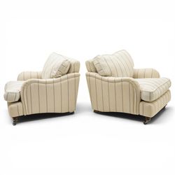 Pair of 20th century Howard shape armchairs, deep seat armchairs in cream and grep striped upholstery, raised on dark supports terminating in front castors