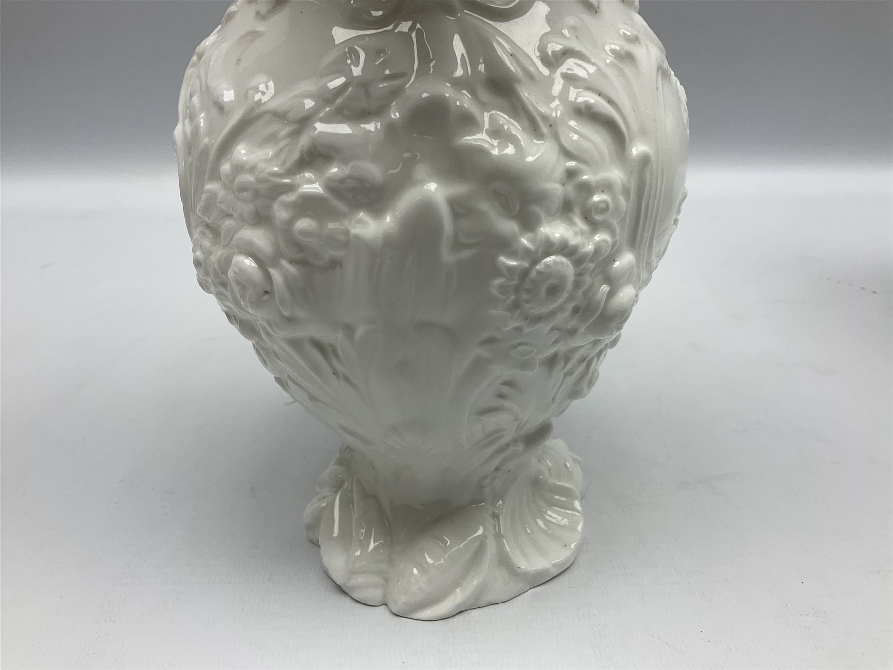 Pair of early/mid 19th century Copeland and Garrett white glazed pitchers, modelled in the Georgian style and moulded with the figures of Venus the Roman Goddess of Love, and Aurora the Roman Goddess of Dawn, within C scroll borders and foliate surround, the naturalistically modelled handle leading to a fruiting vine beneath the rim, upon a spreading base moulded with seashells, with printed green crowned wreath mark beneath, H20cm