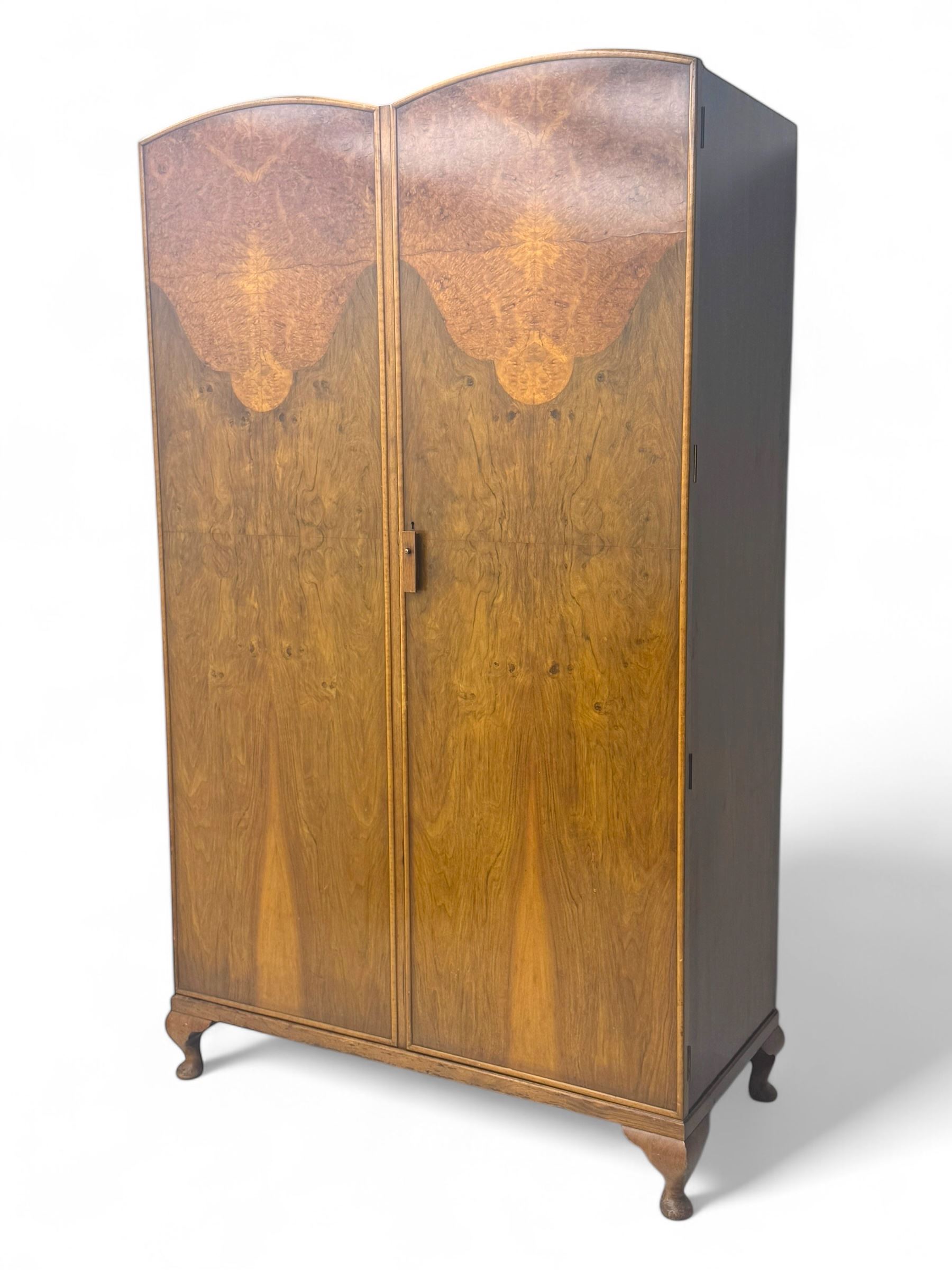 Ashton Leach & Cumberbirch Ltd., Rochdale - early 20th century walnut and mahogany gentleman's wardrobe, arched moulded top with book-matched figured walnut veneers, double doors enclosing fitted interior with hanging rail, tie rack and drawers, raised on cabriole supports