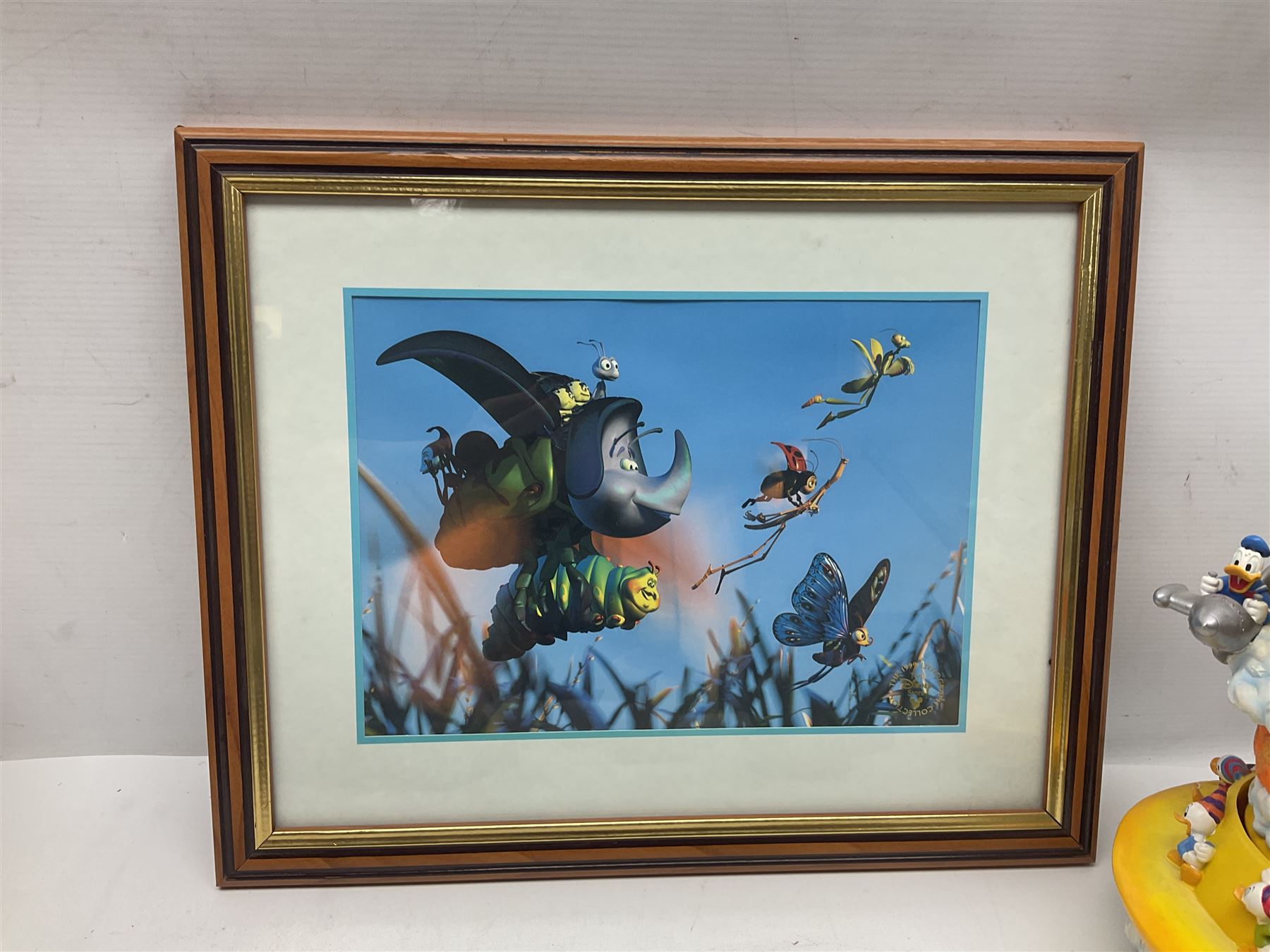 Collection of Disney figures, to include Ardleigh Elliott music box Hunny of the Day, Disney musical snow globe, Micky mouse lazy butler, Framed Bug's Life lithograph etc 