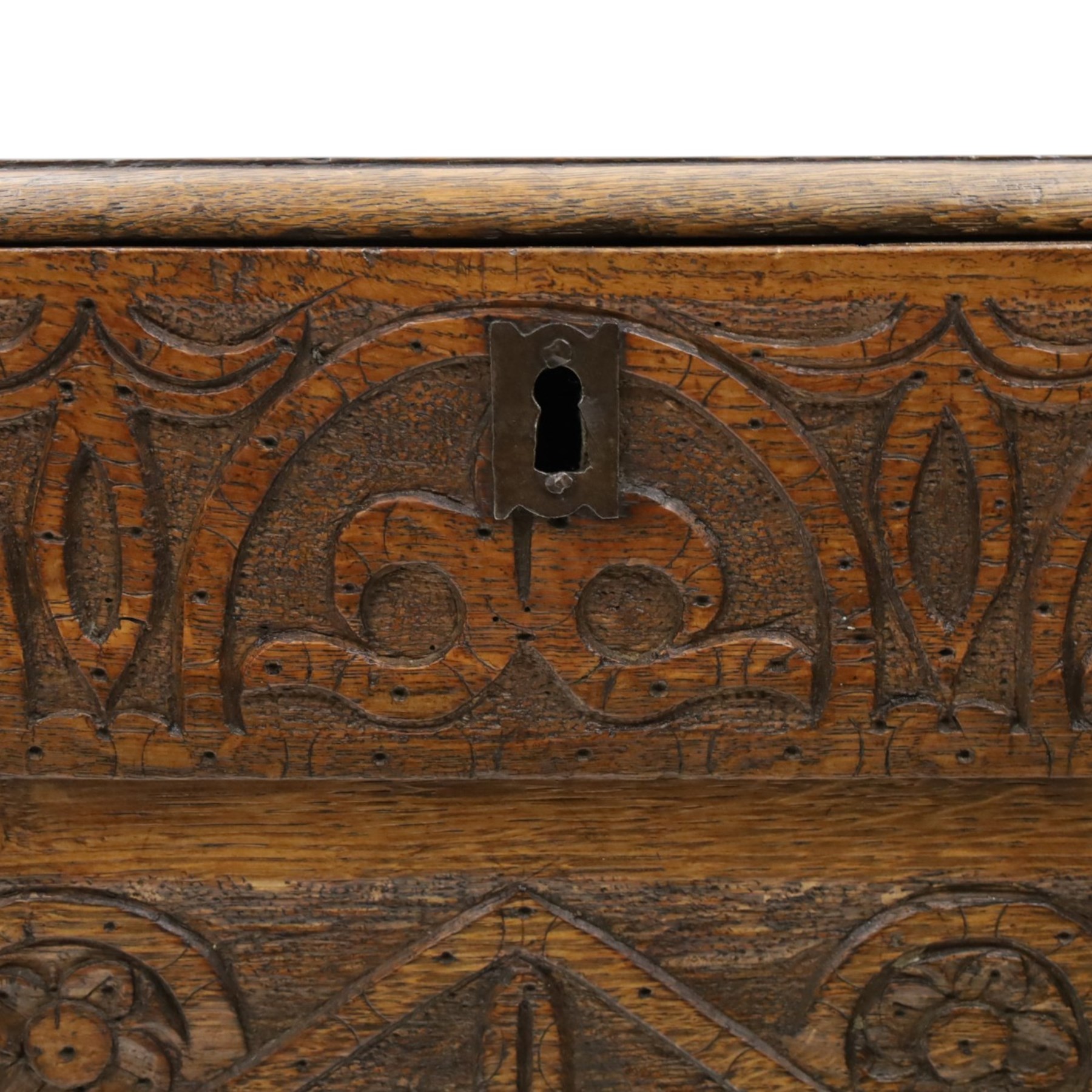 18th century carved oak coffer, rectangular hinged top over a lunette-carved frieze and tracery-style carved triple panelled front, the lower rail carved with repeating anthemion motifs, on square feet
