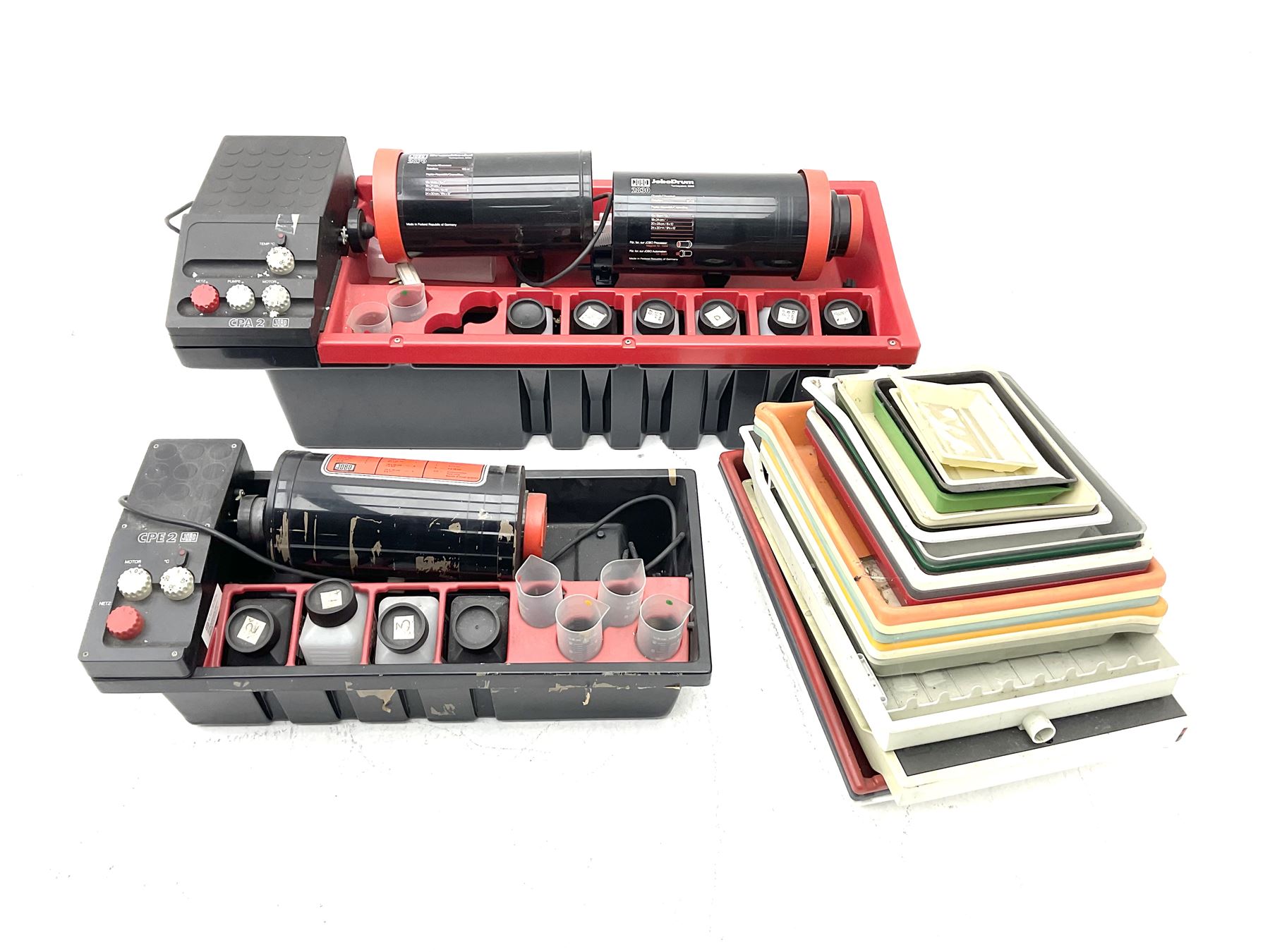 Jobo Colorprocessor CPA 2  fitted with a JoboDrum 2830 drum, DrumModul 2870, three plastic cylinders and six chemistry storage bottles, Jobo Colorprocessor CPA 2, fitted with JoboDrum 4531, four plastic cylinders and 4 chemical storage bottles, and nineteen development trays of various sizes, all untested