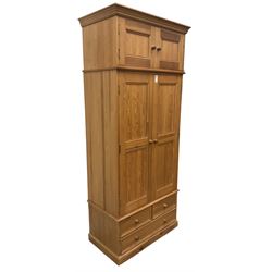 Solid pine double wardrobe, fitted with top box, enclosed by panelled doors, two short and one long drawer, on plinth base 