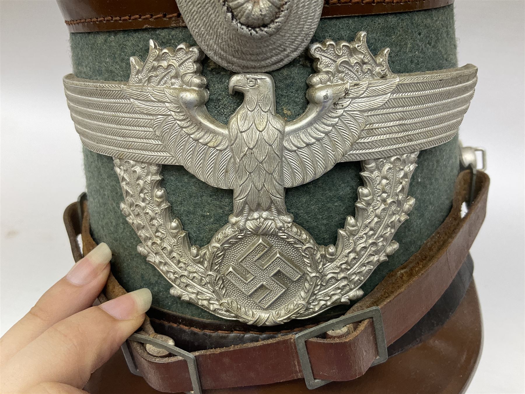 WW2 German rural police shako with helmet plate and liner; bears label 'Hans Romer Echt Fiber-Tschako Neu-Ulm (Donau)'