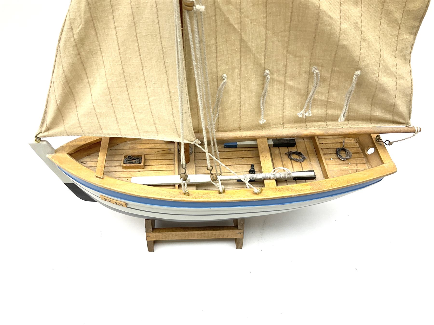 Wooden model of RMS Titanic, on a fixed black stand bearing plaque inscribed 'Titanic 1912', L54cm, H22cm, together with model of a sloop, gaff rigged on stand bearing plaque inscribed 'Sloop' L32cm, H42cm; and model of a fishing trawler on a stand bearing plaque inscribed 'Chalutier' L35cm, H28cm (3)