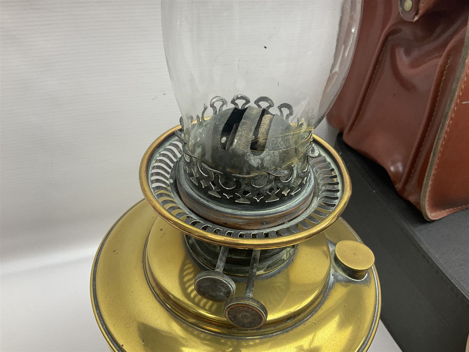 Brass oil lamp, with etched floral glass shade, leather Gladstone style doctors bag, leather satchel and vintage vanity case, three graduating wooden giraffes and other wood and metal ware, lamp H54cm