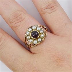 George III 9ct rose gold garnet and pearl mourning ring, single cabochon garnet, with split and seed pearl surround and pierced design shoulders, the back inscribed and dated 1808