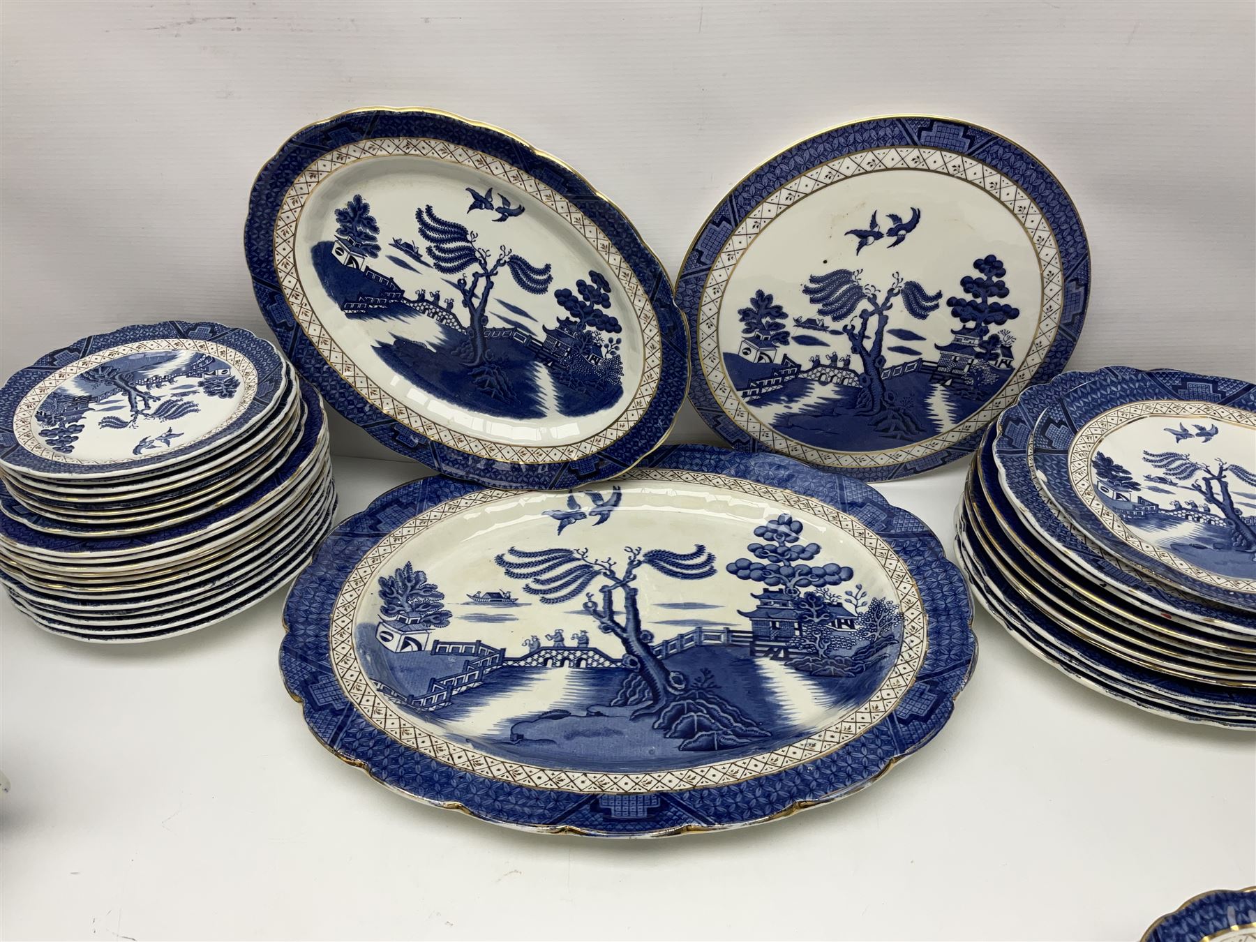 Booths Real Old Willow pattern part tea and dinner service, to include two meat platters, cake stand, teapot, two jugs, sugar bowl, sauce boat, teacups and saucers and a collection of plates and bowls