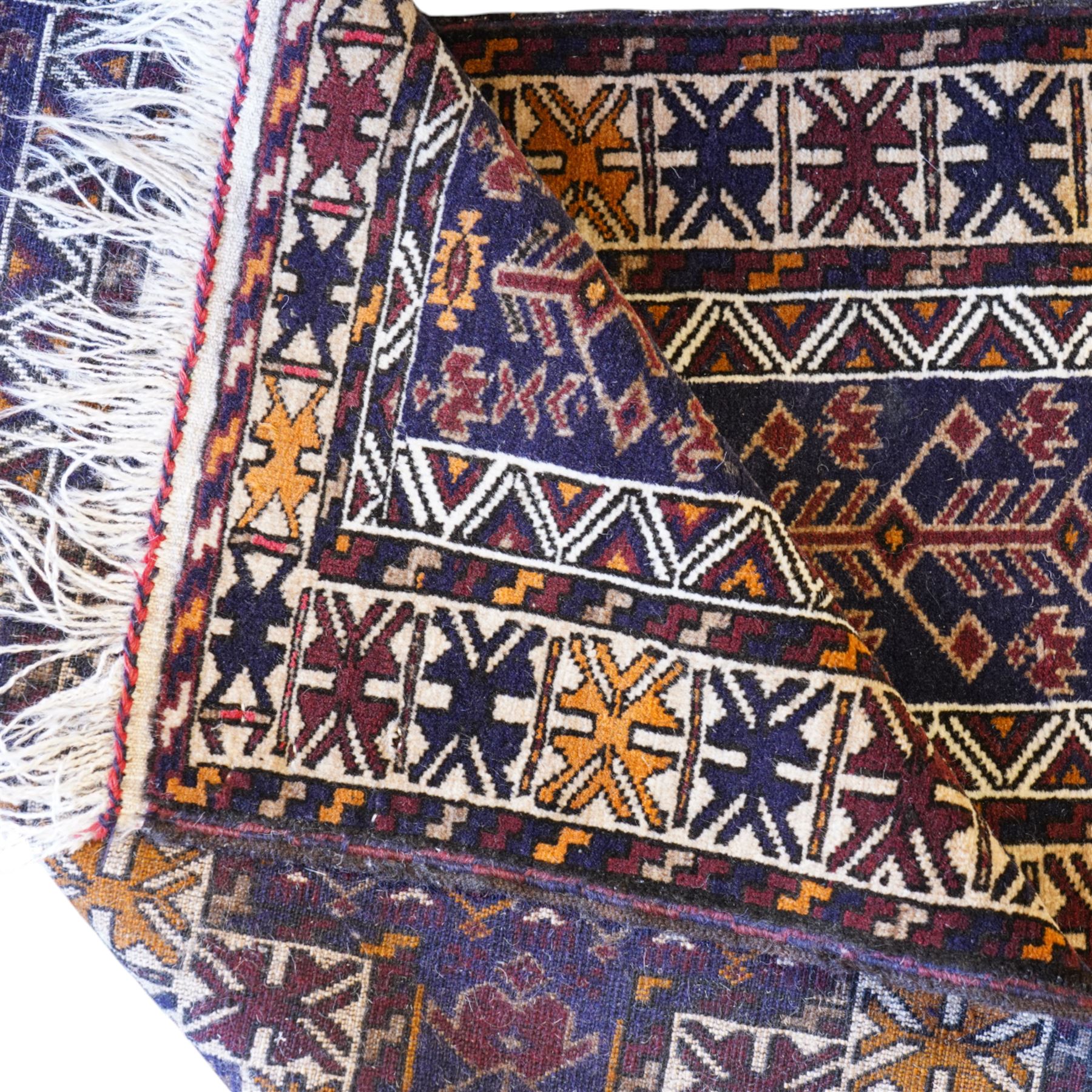 Persian Beluchi indigo ground prayer rug, overall geometric design (147cm x 85cm); together with a Bokhara rust ground rug (146cm x 101cm)