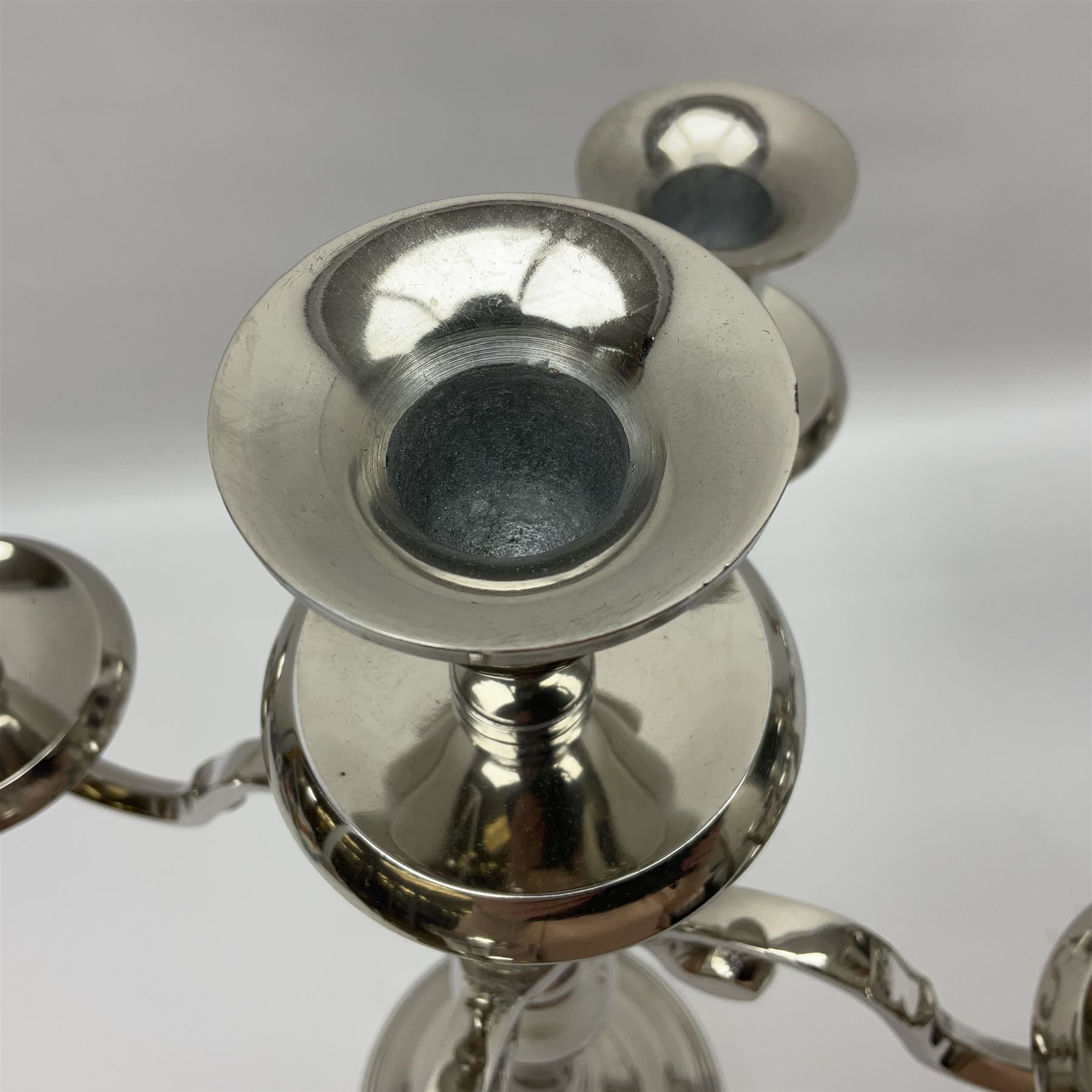 Pair of four branch candelabras, urn-shaped nozzles raised upon scroll branches supported from tapering central stem, with a stepped circular base, H40cm