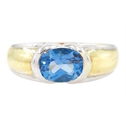 9ct gold topaz ring, single oval cut blue topaz in a half bezel setting with white and yel...