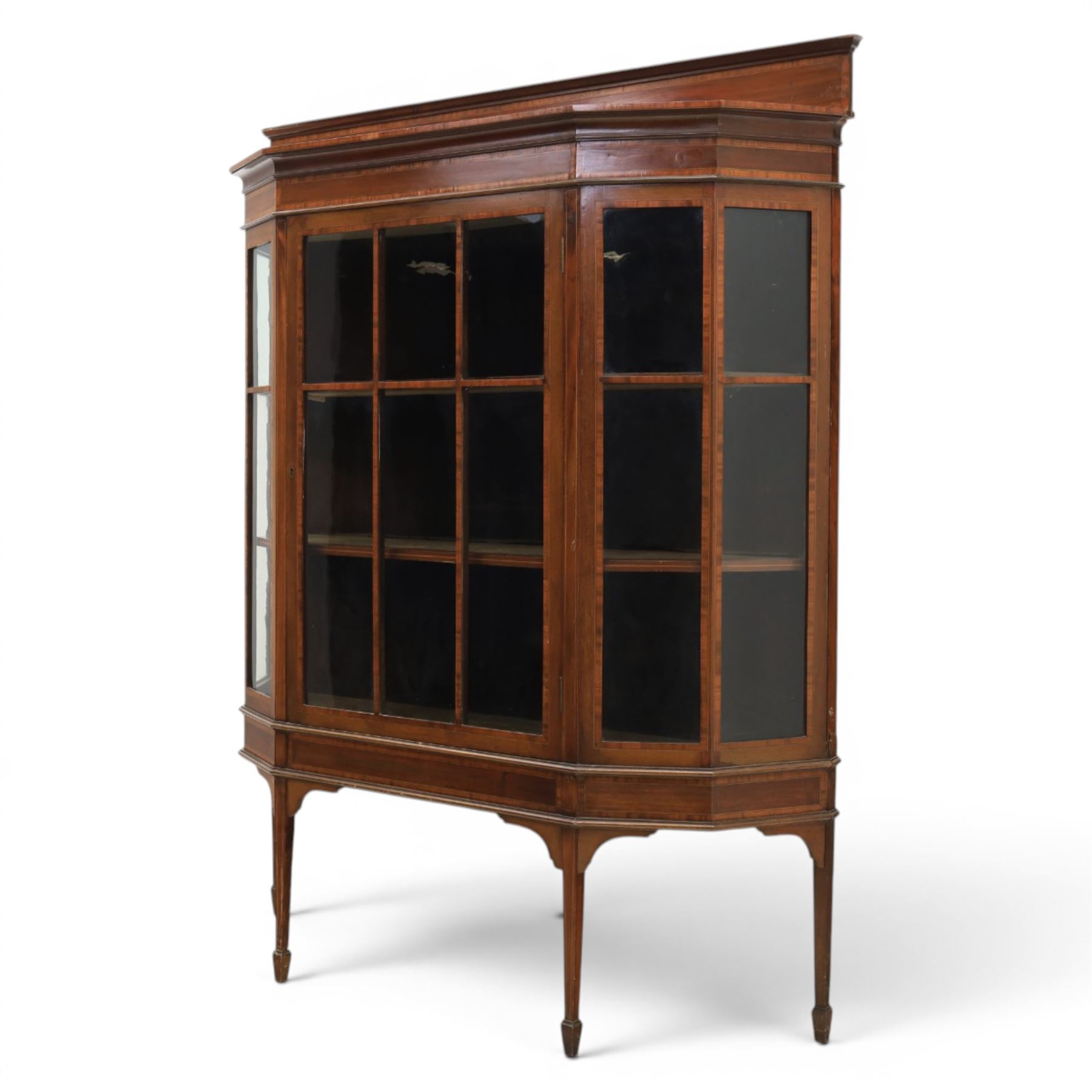 Edwardian inlaid mahogany display cabinet of rectangular canted form, galleried top with crossbanded inlay, above a glazed cabinet enclosing  baize lined shelves, raised on square tapering legs terminating in spade feet  