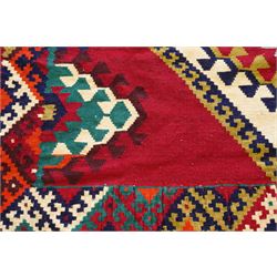 Persian Qashqai crimson ground rug, the central narrow ivory field decorated with repeating hooked geometric lozenges in multicolours, with a densely decorated guard band