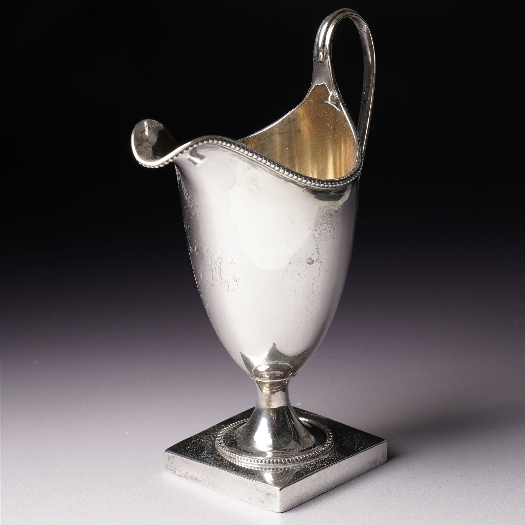 George III silver helmet shape cream jug engraved with a monogram with loop handle on square base H15cm London  1790 Maker Hester Bateman