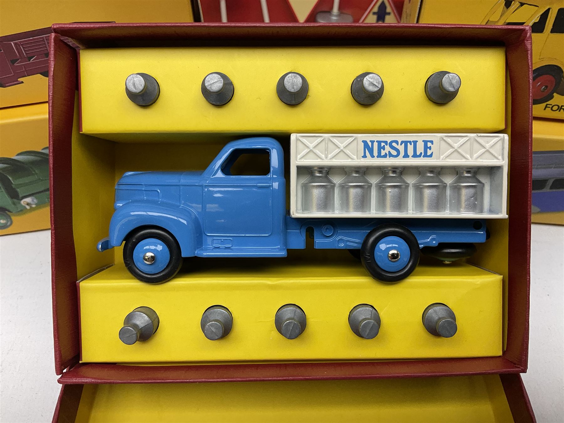 Ten Atlas Dinky die-cast models and accessories including, Bedford TK Tipper no. 435, Austin Wagon no. 412, two Miniatures, 25 O Camion Laiter, 'Panneaux De Signalisation Routiere' and others (10)