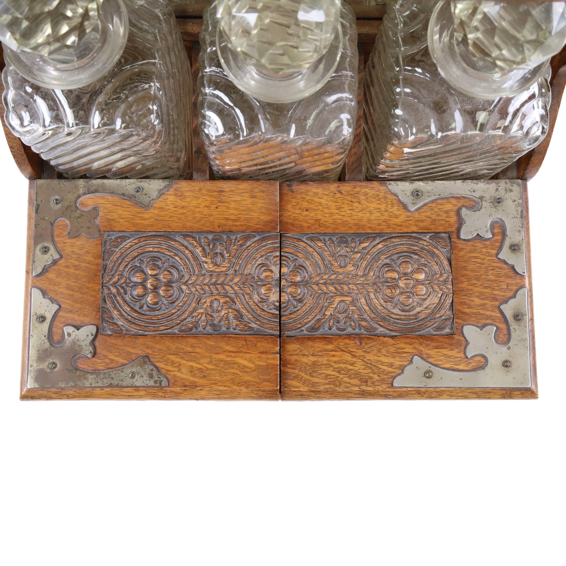 Victorian brass mounted oak tantalus, containing a set of three decanters, fitted with a games compendium to the front, H32cm