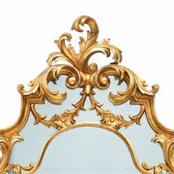 Rococo design carved gilt wood wall mirror, shaped and moulded frame decorated with scrolling leafage, plain mirror plate divided by mouldings