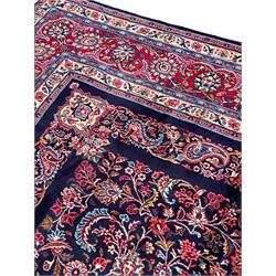 Persian Hamadan indigo ground carpet, the field decorated with central rectangle and outer band, overall floral pattern with cusped central medallion and surrounding leafy branches with palmettes, the border with scrolling branches decorated with further palmettes, within floral pattern guard stripes