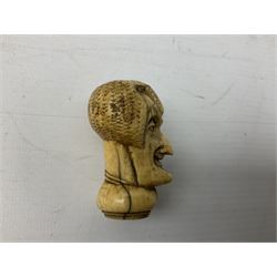 19th century carved ivory walking cane handle, modelled as the head of a greyhound with inset glass eyes, together with a further 19th century ivory example, modelled as a caricature of a gentleman's head, (2)