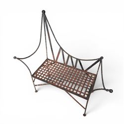 Victorian design wrought iron garden bench, with asymmetrical rope-twist frame, arched back and sides over out-swept arm terminals with ball finials, flanking a lattice seat, in antique black-painted weathered finish
