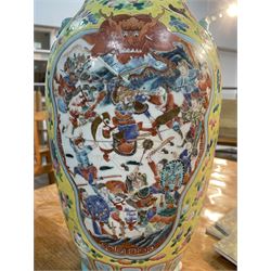 19th century Chinese famille rose yellow ground porcelain vase, of baluster form with twin applied mask ring handles, the body decorated with two shaped reserves mounted with dragon heads, depicting warriors at battle and at court, the neck with two smaller conforming figural reserves, upon a yellow ground decorated with exotic birds amidst scrolling blossom, H45.cm