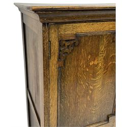 Early 20th century oak triple wardrobe, three panelled doors with geometric mouldings and fretwork spandrels, the interior fitted with slides and hanging rail