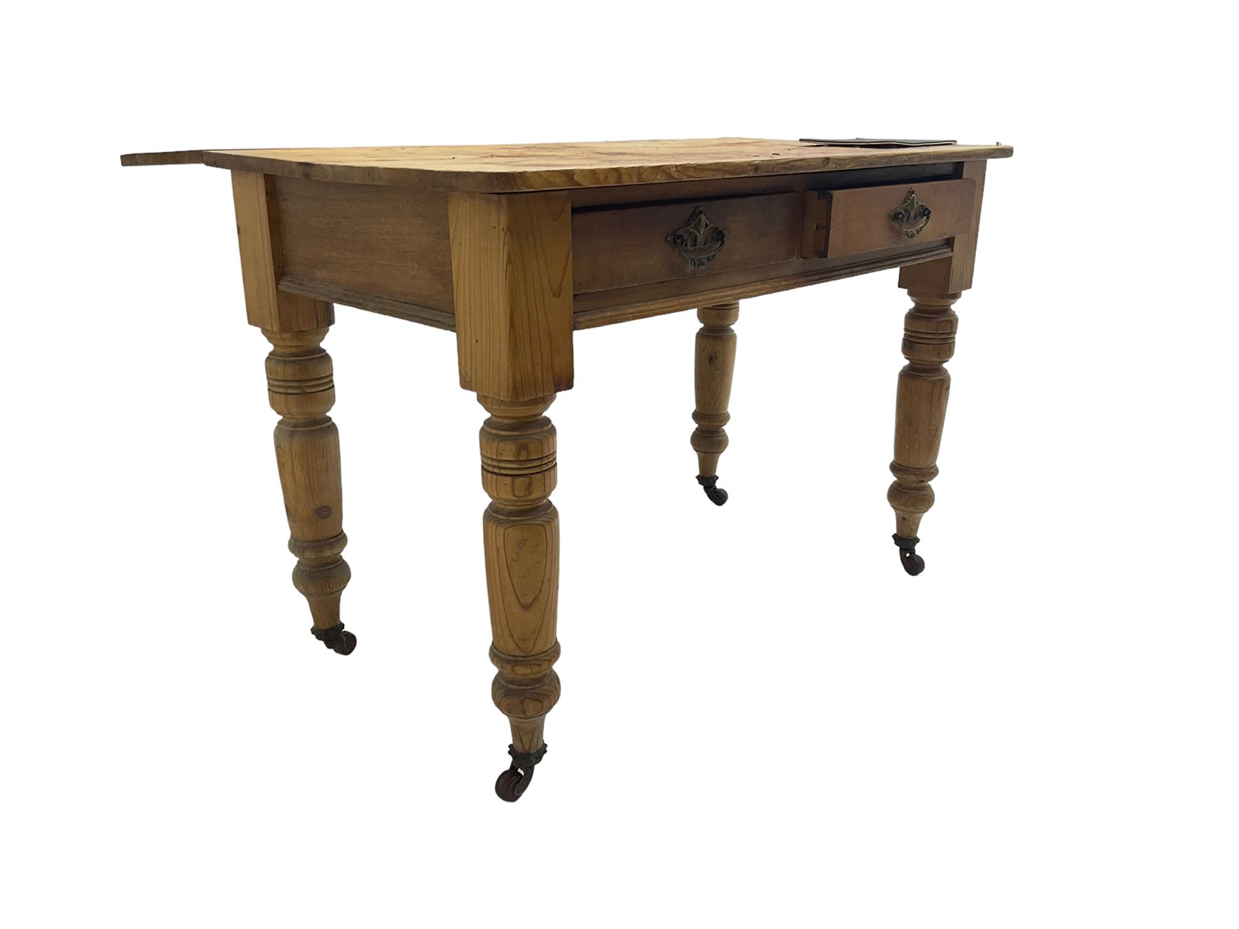 Traditional rustic pine dining table, rectangular top fitted with two drawers, raised on turned tapering supports on ceramic castors